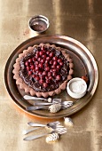 Black forest chocolate tart with custard cream and cherries in serving dish