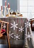 A table laid for Christmas decorated with paper snowflakes