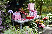 Geschenke & Blumensträusse auf Tisch im sommerlichen Garten