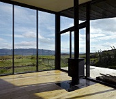 Modern, empty living room with free standing wood burning stove and panoramic view
