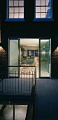 Apartment house at dusk with open patio doors and a view of a lighted dining room