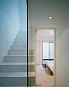 White lacquered stairs with glass dividing wall and view through an open bedroom door