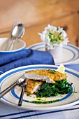 Breaded chicken escalope with spinach and lemons