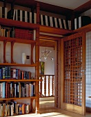 Library in Asian style with open door and wood lattice with a view of a staircase