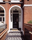 Entry way with a round arch in the brick facade of an English row house