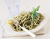 Pesto Pasta on a Plate with Fork and Lemon Wedge