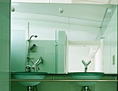 Designerbad mit Waschschüsseln aus Glas und Designerarmaturen vor Wandspiegel