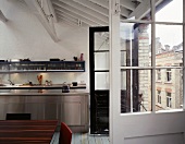 Open balcony door in a converted loft with stainless steel kitchen