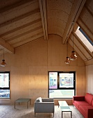 Holzverkleidung an Wand und Decke und farbige Sofagarnitur im minimalistischen Wohnraum