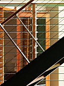 Detail of a metal stairway with railings and horizontal wire cables