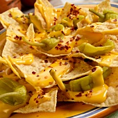 Tortillachips mit Käsesauce und Chiliflocken