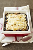 An aubergine bake in a baking dish with cheese on top
