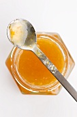 Apricot jam in a jar with a spoon (seen from above)