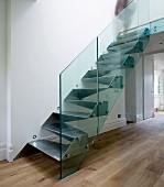 Metal, cubist designer stairs with glass balustrade in purist foyer