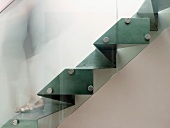 Seitenansicht einer skulpturalen Stahltreppe mit Glasgeländer