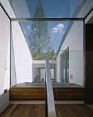 Modernes Treppenhaus mit grosser Fensterfront und Glasdach mit Blick auf Innenhof