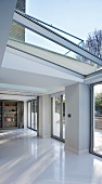 Puristischer Wohnraum im modernen Anbau mit Glasdach und Stahlkonstruktion