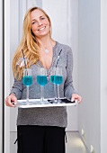 A woman serving blue drinks at Christmas time