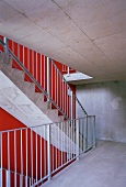 Concrete stairway with red wall and metal banister on the concrete steps