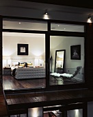 View through a terrace window into an illuminated bedroom