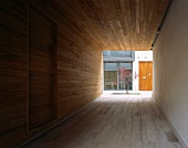 Wood paneled passageway and view of a tree in a courtyard