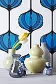 Vases with tulips in front of vintage wallpaper decorated with an onion pattern