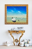 Picture in a gold frame over a rococo wall table and porcelain crockery