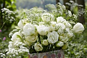 A bunch of white tulips (tulipa Maureen Double) in a vase in a garden