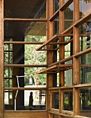 View of retro stainless steel lamp through traditional-style wood and glass facade with open windows