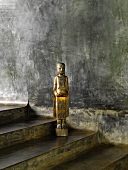 Metal figurine of girl on concrete steps