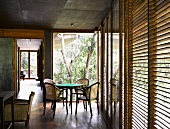 Traditional-style dining area in front of open terrace door and closed wooden blinds on windows