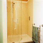 A semi-tiled shower cubicle with a curved wall and a stainless steel heated towel rail