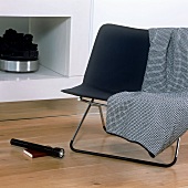 A chair with a stainless steel frame in front of a fireplace