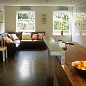 A walnut kitchen counter with a stainless steel bracket with a comfortable sofa in front of a window