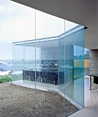 A contemporary, transparent house with a glass facade by the sea