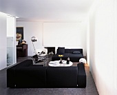 White modern living room with black seating on a grey floor