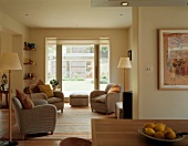 Graue Sessel mit Zierkissen und Stehlampen im skandinavischen Stil in offenem Wohn-/Essbereich mit grossflächiger Fensterfront