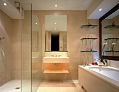 Komplette Natursteinverkleidung in Bad mit bodengleicher Dusche und grossen Spiegeln
