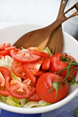 Tomato salad with salad servers in bowl