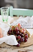 Red grapes and soft cheese on a wooden board