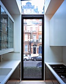 Narrow, ceiling-height kitchen window with transom and view of London street