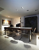Modern dining table with wire mesh chairs on white tiled floor