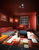 Red room with multi-coloured seat cushions and a patchwork rug