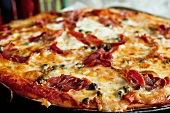 A pizza topped with ham and capers (close-up)