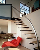 Floating stair treads on wall of living space with red chaise longue