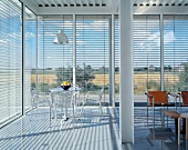 Offener moderner Wohnraum mit Panoramafenster und halbgeschlossener Jalousie