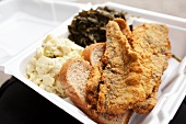 Fried Fish with Potato Salad and Greens in To Go Container