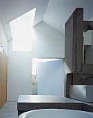 Modernes Bad mit Raumteiler und Ablage aus Beton in zeitgenössischer Architektur mit Oberlicht
