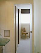 Modern bathroom with open sliding door and view of chair
