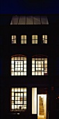 English house with illuminated lattice windows at night